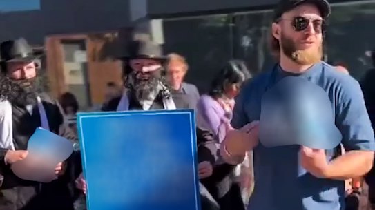 Joel Davis (right), of the neo-Nazi National Socialist Network, at a Kooyong pre-polling centre on Wednesday.