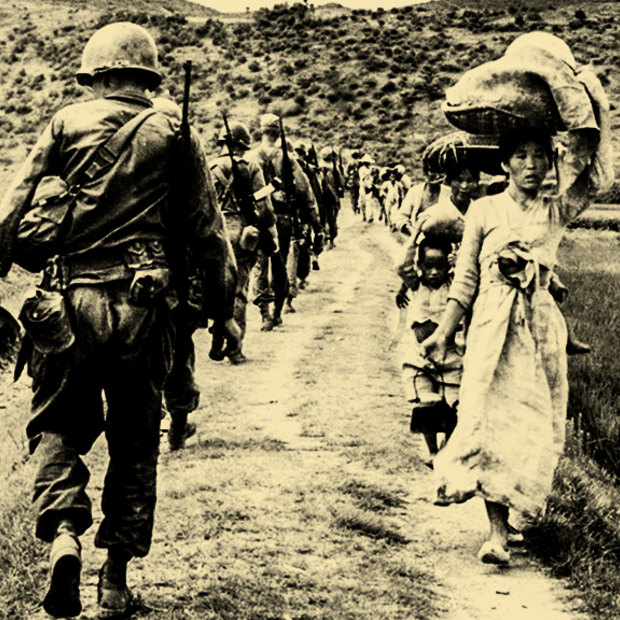 US soldiers file past Korean women and children carrying their possessions in 1950. 