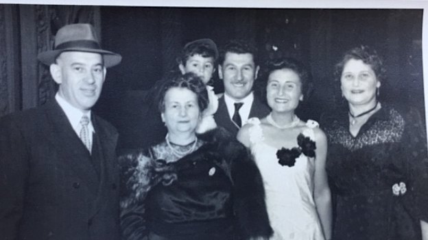Harry Skorupa, a distant relative of Jaku’s, Flore’s mother Fortunee Molho, Eddie carrying Michael, Flore, and Bella Skorupa. The families lived together on arrival in Sydney and are celebrating a fellow survivor’s wedding  in 1951.