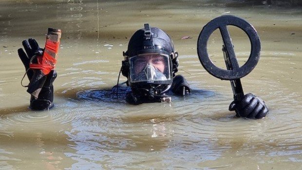A police diver recovers parts of a rifle believed to have been used in the fatal shooting.