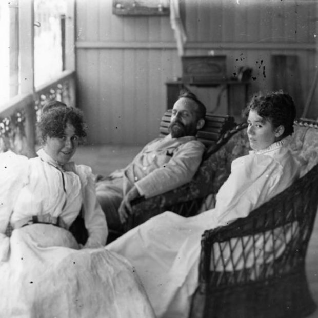 Queensland Government Electrician Edward Gustavus Campbell Barton relaxing on the verandah with two women in 1890.
