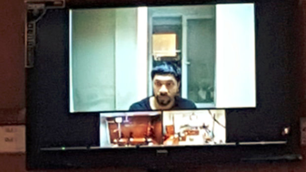 Prakash appears on a video screen during an earlier court appearance.