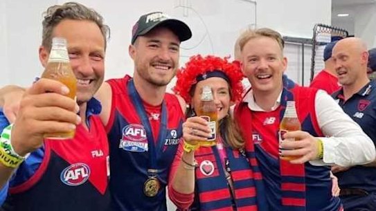 Melburnians Hayden Burbank, left, and Mark Babbage, right, pictured with Demons player Alex Neal-Bullen, were questioned by police after allegedly breaking restrictions to travel to the grand final in Perth.