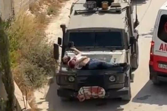 A wounded Palestinian man was strapped to the bonnet of a vehicle by Israeli troops.