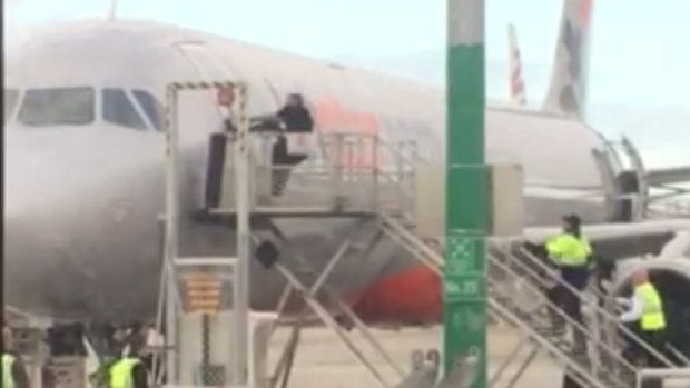A man was arrested at Melbourne Airport on Thursday after he ran across the tarmac then tried to rip open the door of a Jetstar plane.