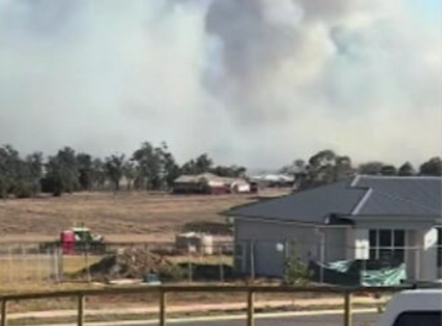 Smoke billows from fires burning behind homes in the Lockyer Valley.