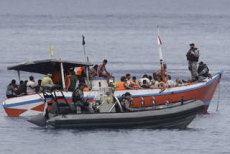 An Indonesian fishing boat filled with asylum seekers is processed by Australian authorities at Flying Fish Cove, Christmas Island.