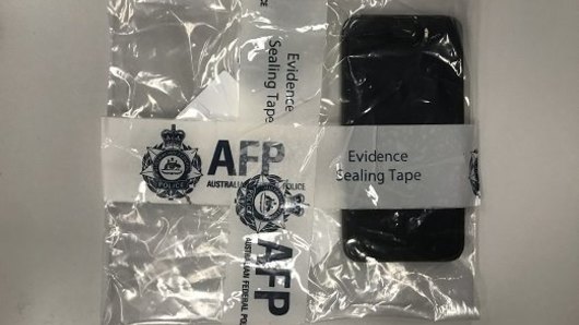 Australian Federal Police investigators seized a mobile phone during a search at a home in Brisbane.
