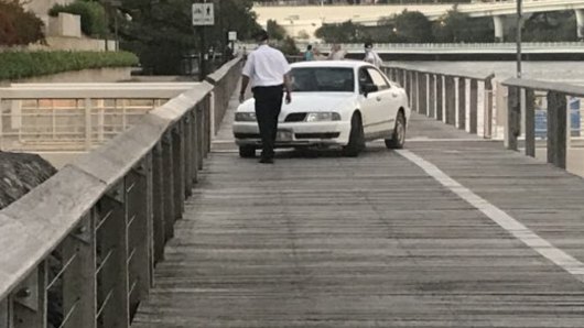 Pedestrians watch on as police stop the car on the South Bank pedestrian boardwalk.