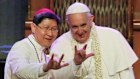 Filipino Cardinal Luis Antonio Tagle, and Pope Francis give the popular hand sign for “I love you” in Manila in 2015.