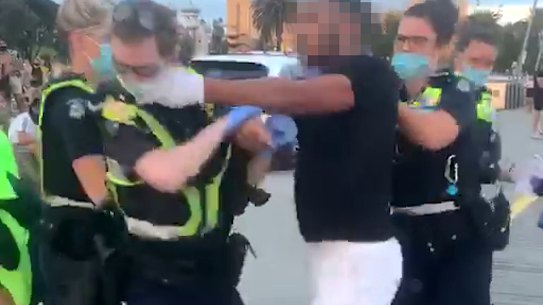 A man is arrested by police on the St Kilda beach foreshore on Saturday night. 
