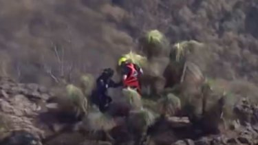 A rescue helicopter crew works to airlift someone from Mount Mitchell in the Main Range, in Queensland's Southern Downs region.