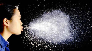 A sneeze can release droplets containing the virus.