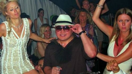 Jho Low, who is attempting to prevent the publication of a book into the 1MDB scandal, parties with Paris Hilton (left) and her sister Nicky in 2010.