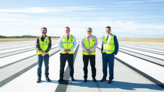 Celebrating the end of the runway's construction are (from left) deputy project manager Ben Garnett, Brisbane Airport Corporation chief Gert-Jan de Graaff, project director Paul Coughlan and airport assets general manager Krishan Tangri.