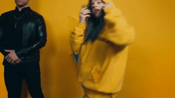 Pop star Billie Eilish removes her teeth aligner in a music video clip.