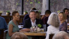 Hey good-looking: Barrenjoey executive chairman Matthew Grounds, at a table with three women, during his appearance on HBO sitcom Curb Your Enthusiasm.