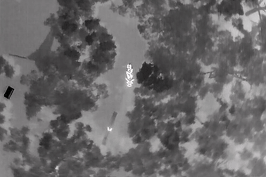 Drone footage of a Fire & Rescue strike team carrying out the night-time rescue of two people and six dogs with the help of a raft made from a bamboo fence.