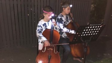 Josie, 11, and Eliza, 9, played 'The Last Post' this morning outside their home in Hawthorn. 