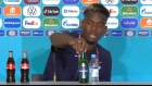 Paul Pogba removes a bottle of Heineken from his press conference. 