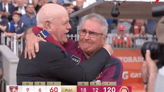 AFL Legend Leigh Matthews hugs premiership coach Chris Fagan.