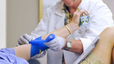 A nurse bandages the arm of a donor during a community blood drive.