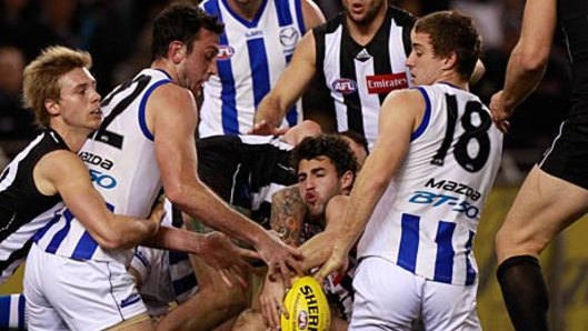 Congested traffic: Collingwood and North Melbourne players flock around the ball.