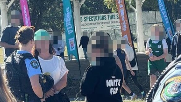 Police talk to a mother at Heffron Park on Saturday after her alleged antisemitic outburst at an under 12s netball game. She has been charged with offensive language in a public place.