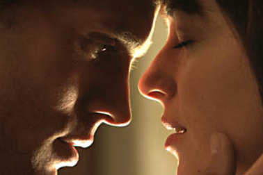 Jamie Dornan and Dakota Johnson appear in a scene from ‘Fifty Shades of Grey’.