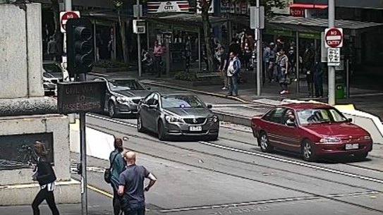 The offender on Swanston Street with police a metre behind him.