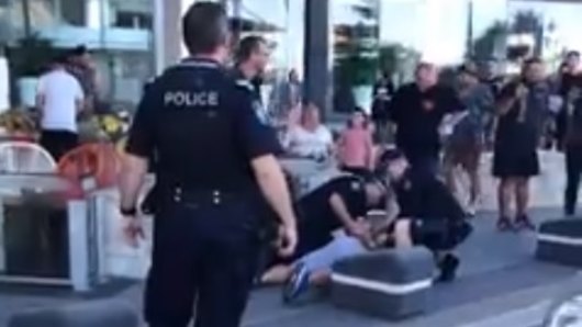 Police make an arrest after "peaceful" Kurdish protesters were attacked on the Gold Coast on Sunday.