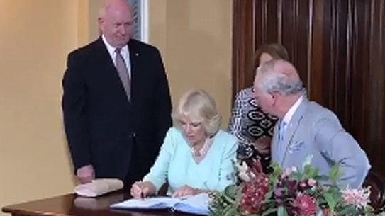 Duchess left holding the umbrella as she arrives in Brisbane with Prince Charles