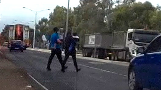 Childcare centre workers take the children back across the road. 