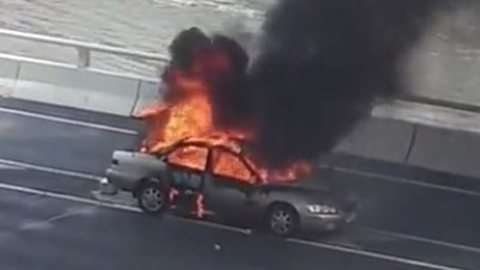 The car goes up in flames on the Riverside Expressway on Friday afternoon.