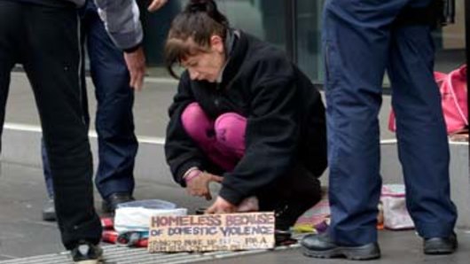 Police check a beggar's bowl in Melbourne.