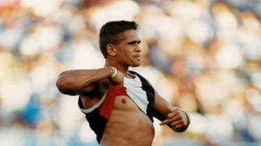 St Kilda footballer Nicky Winmar raises his jumper in response to racial taunts from Collingwood fans at Victoria Park in 1993.
