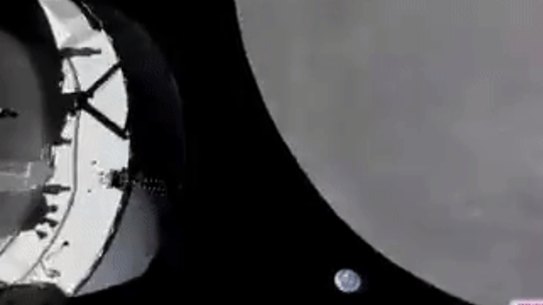 NASA’s Orion capsule nears the moon, Earth is in the background.