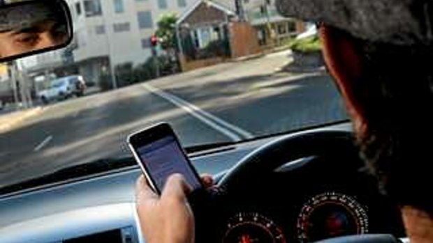 A driver illegally uses his mobile phone.