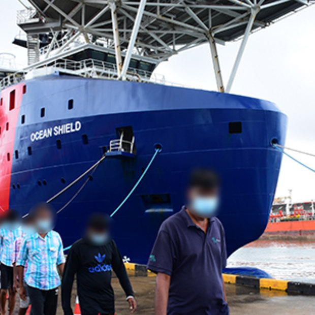 Sri Lankan men are led off the Australian Border Force ship Ocean Shield in Colombo in August.