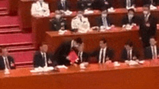 Former president Hu Jintao escorted from the closing ceremony in Beijing.