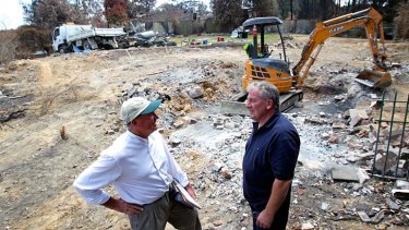 Family team: Builder Philip Bartush (left) consults his brother Dave about plans for a fire-resistant house to replace the one that was destroyed.