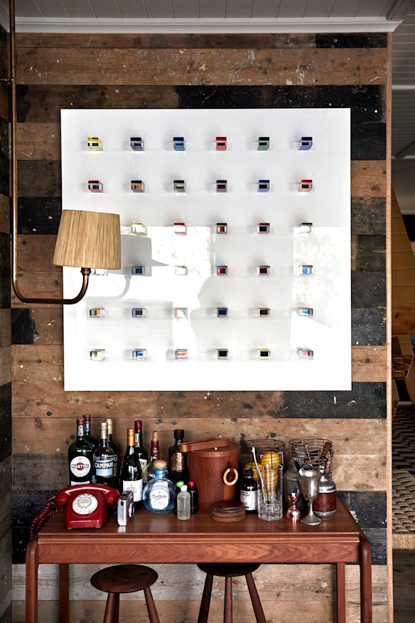 An artwork by Mauro Perucchetti hangs above the bar, a repurposed vintage Danish console.