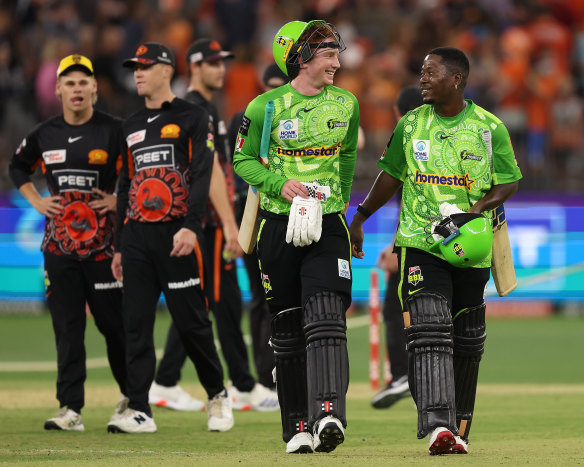 Hugh Weibgen and Sherfane Rutherford of the Thunder walk from the field after winning the BBL match against the Perth Scorchers.