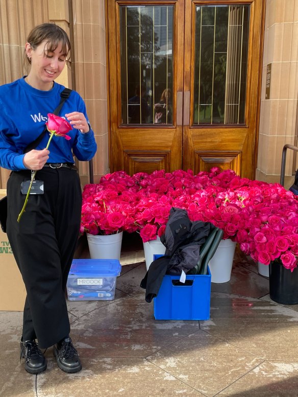 An art gallery volunteer preps the roses for tonight.