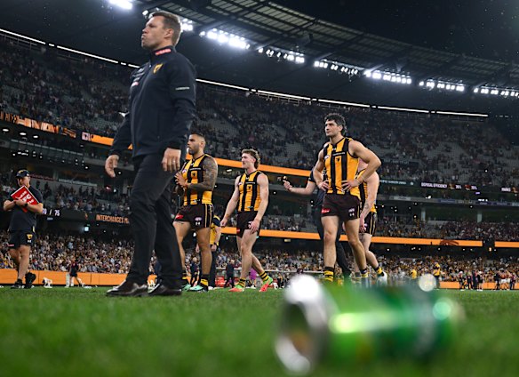 Poor look: Sam Mitchell and his Hawks leave the MCG after can and bottles had been flung on to the ground.