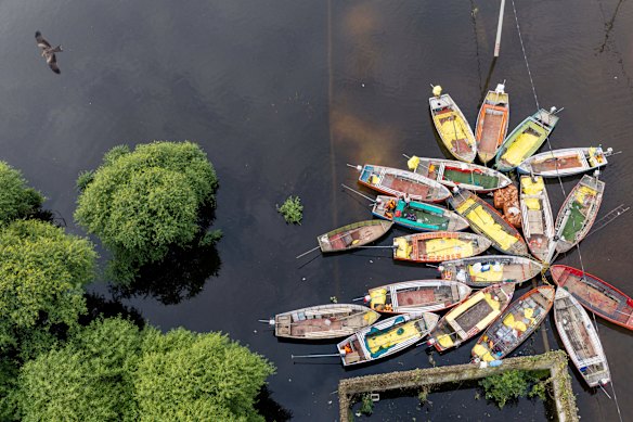 A kite flies over rescue boats moored next to a police building as water from the overflowing River Gomti floods the Faizullaganj residential area in Lucknow, India.