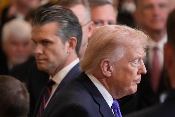 US President Donald Trump walks past War Secretary Pete Hegseth at the White House on Monday.