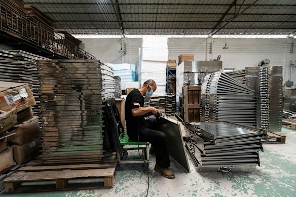 A worker making ovens and cookware at a small factory in Guangzhou. The company plans to acquire a robotic arm that uses artificial intelligence to replicate the way a person welds the sides of an oven. 