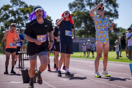 Chug and run: Competitors in the Aussie Beer Mile fuel up on beer before running another lap.