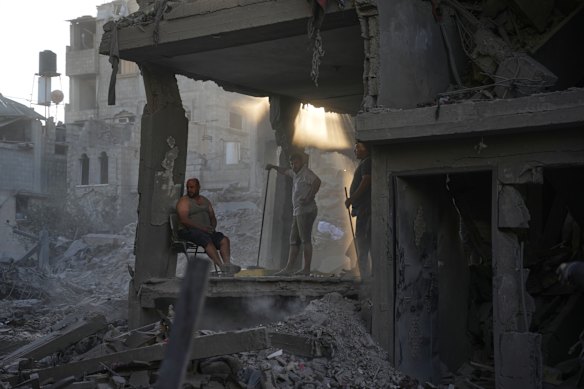 Palestinians clear the rubble of a building that was destroyed in an Israeli airstrike, at al-Maghazi refugee camp, central Gaza Strip.